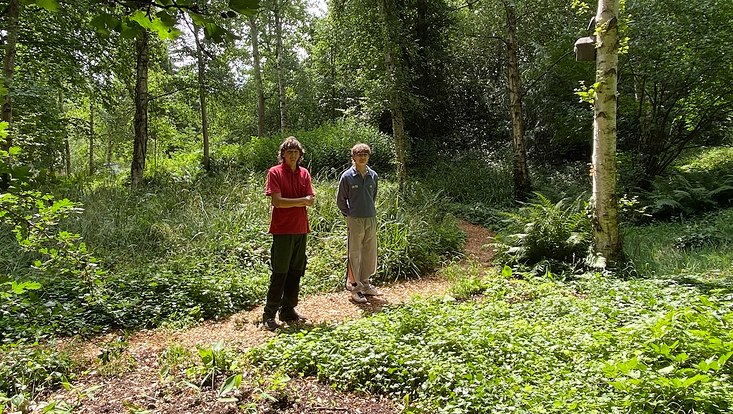 Zwei junge Männer auf einer Waldlichtung im Botanischen Garten Hamburg