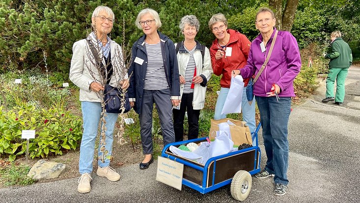 Die Ehrenamtlichen des Loki-Schmidt-Gartens stehen um einen kleinen Handwagen herum